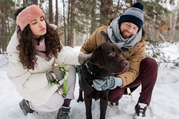 Mann und Frau streicheln Hund