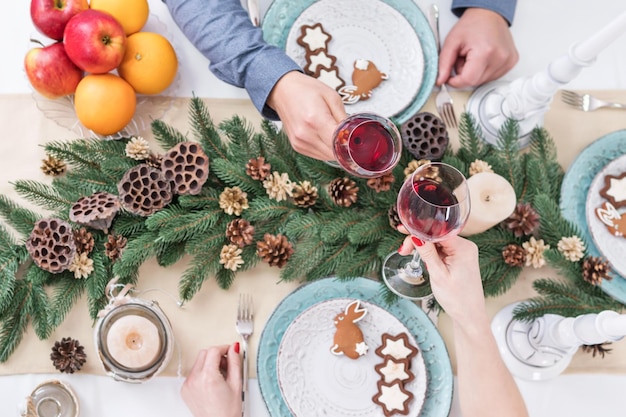 Mann und Frau trinken Wein am Weihnachtstisch, Ansicht von oben