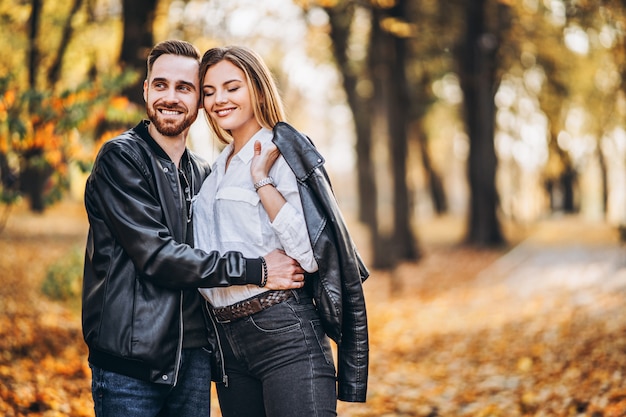 Mann und Frau umarmen und lächeln im Herbstpark.