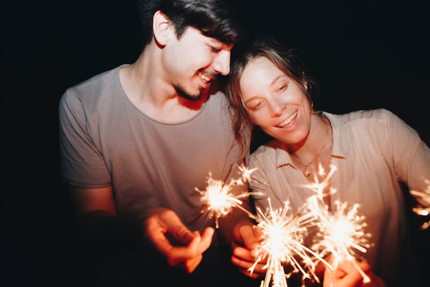 Mann- und Frauenpaare, die mit Sparklers Feier und festlichem Parteikonzept spielen