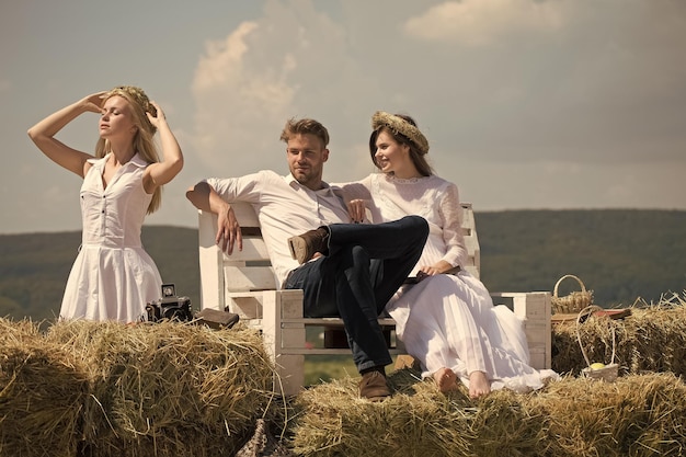 Mann und glückliches Mädchen, das auf Bank auf Berglandschaft sitzt