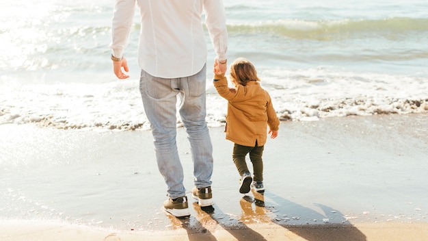 Mann und kleiner junge stehen am meer