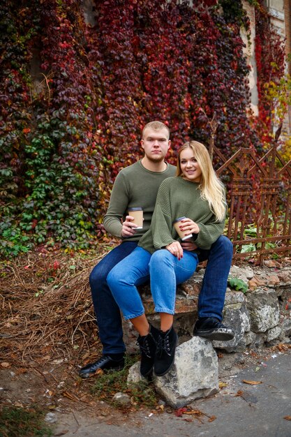 Mann und Mädchen in Jeans und grünen Pullovern