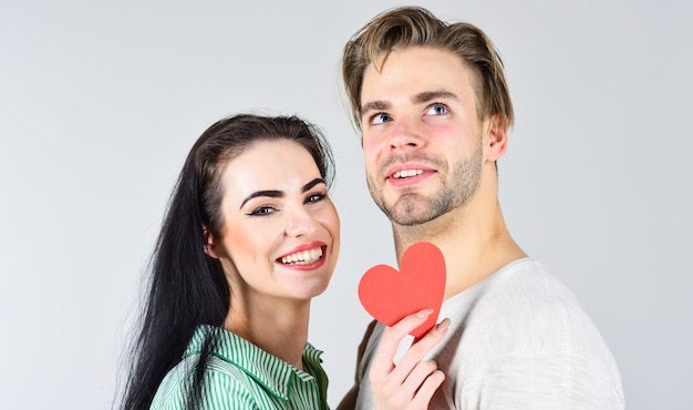 Mann und Mädchen verliebt. Romantische Ideen feiern den Valentinstag. Glücklich zusammen. Verliebte Mann- und Frauenpaare halten rote Papierherz-Valentinskarten. Valentinstag und Liebe. Valentinstag-Konzept.