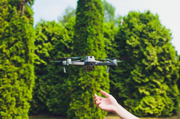 Mann und sein Drohnen-Quadrocopter in einem Wald auf grünem Hintergrund