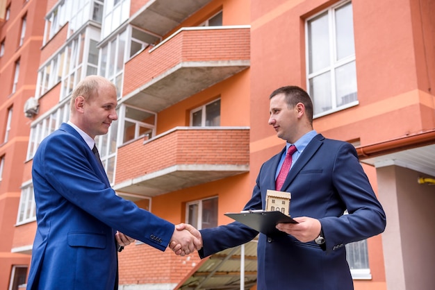 Mann unterzeichnet Vertrag über Wohnungskauf gegenüber Neubau