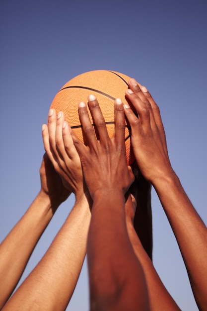 Mann vereinigt Nahaufnahme der Hände, die einen Basketball hochhalten