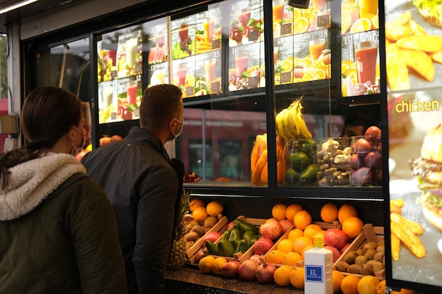 Mann wählt ein Getränk und sieht sich die Speisekarte in einem Straßencafé mit Säften und Smoothies an