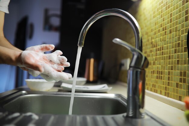 Mann wäscht Geschirr im Waschbecken im Restaurant Leute waschen auch das Geschirr Reinigungslösung