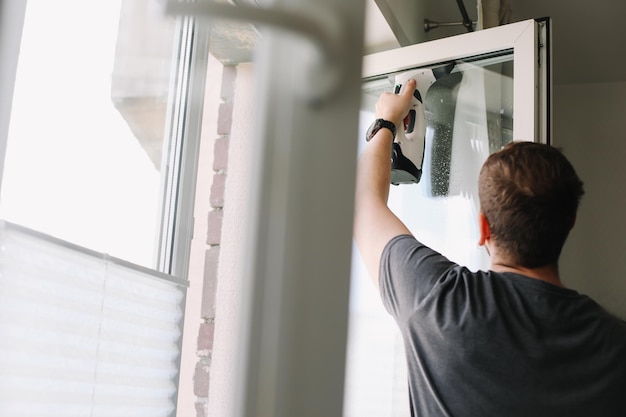 Mann wäscht und putzt Fenster zu Hause Hausarbeit und Haushaltshygiene