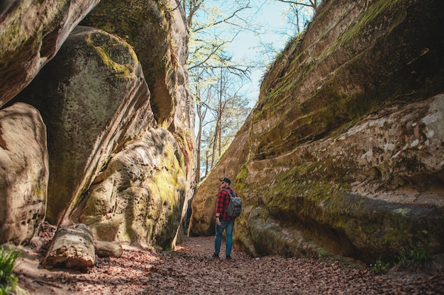 Mann Wanderer mit Rucksack zu Fuß durch Trail in Canyon Dovbush rocks Ukraine
