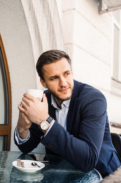 Mann wie Kaffee Gut aussehender Mann mit Tasse Kaffee im Café Morgenlebensstil des Menschen