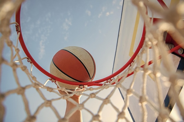 Mann wirft den Ball in Hoop-Hände und Basketball-Dunk in Basket-Slam-Dunk in Bewegung