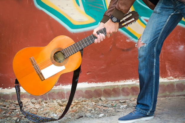 Mann zerstört Gitarre in einem zerstörten Gebäude