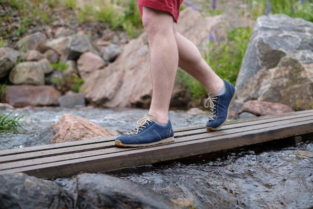 Mann zu Fuß auf einer Holzbrücke über Wasserstrom