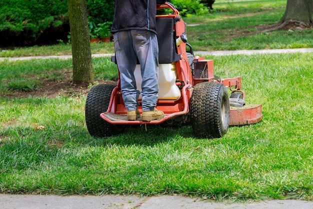 Mannarbeiter, der Gras im Sommer mit einem professionellen Gärtner schneidet, der Rasen mäht