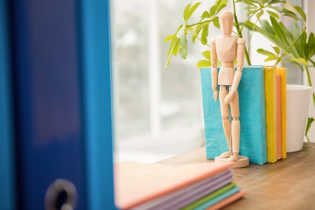 Mannequin und Stapel Bücher auf Holzfensterbrett