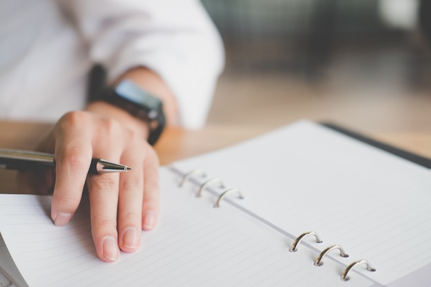 Mannes Hand hält Stift. Schüler lernen mit Notebook