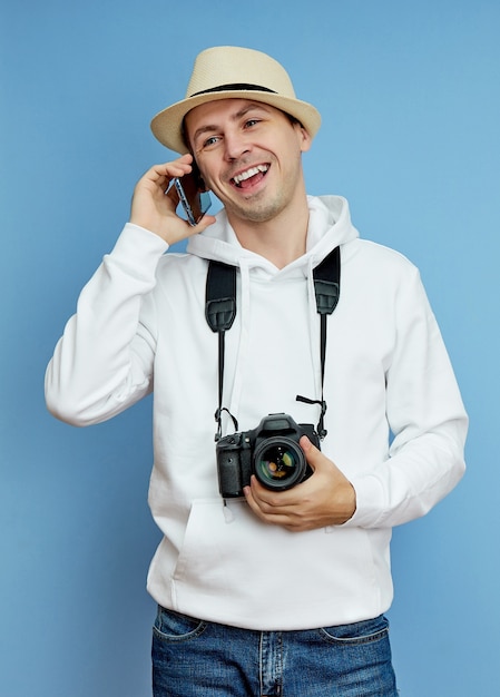 Mannfotograf mit einer Kamera, die am Telefon spricht