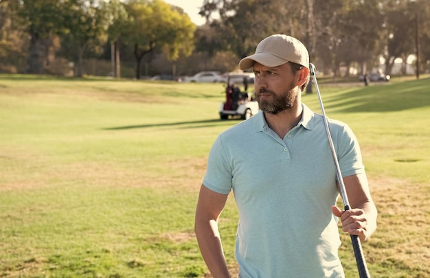 Manngolfspieler in der Kappe mit Golfschläger auf Sommersport des grünen Grases