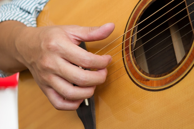 Mannhände, die klassische Gitarre spielen