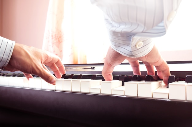 Mannhände, die Klavier spielen. Klassische Musik. Kunst und abstrakter Hintergrund.