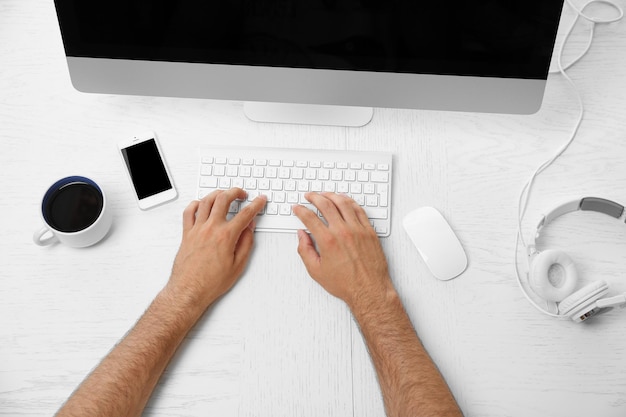 Mannhand auf Computertastatur auf Tischplatteansicht