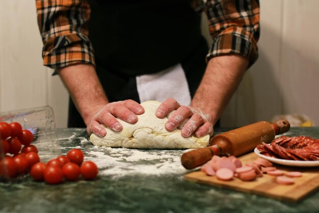 Mannhand bereiten Pizzateigbelag vor