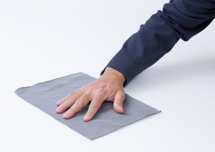 Mannhand mit Lappen, der den Boden reinigt