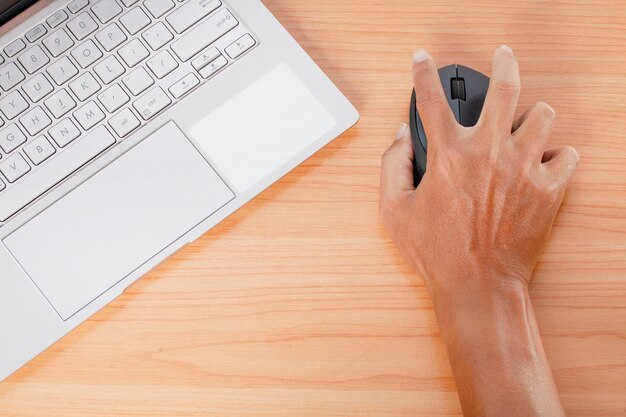 Foto mannhand unter verwendung eines computer-laptops auf schreibtisch