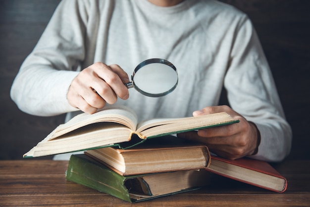 Mannhandlupe und Bücher auf dem Tisch