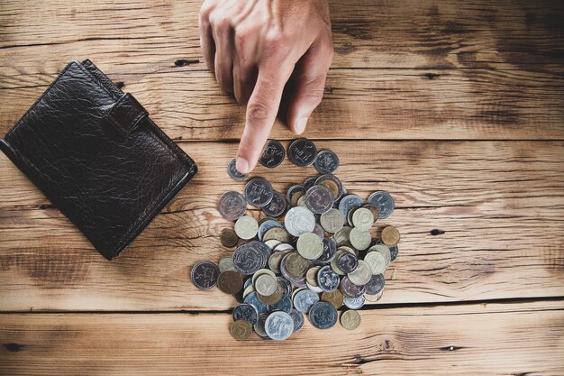 Mannhandmünzen mit Brieftasche auf Schreibtisch