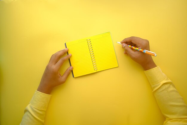 Mannhandschrift auf Notizblock auf gelbem Hintergrund