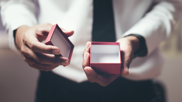 Foto mannholding öffnen die leere rote geschenkbox.