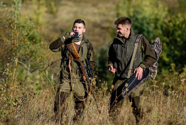Mannjäger mit Gewehrpistole Bootcamp Jagdfertigkeiten und Waffenausrüstung Wie die Jagd zum Hobby wird Militäruniformmode Freundschaft der Männerjäger Jäger mit dem Zielgewehr im Wald