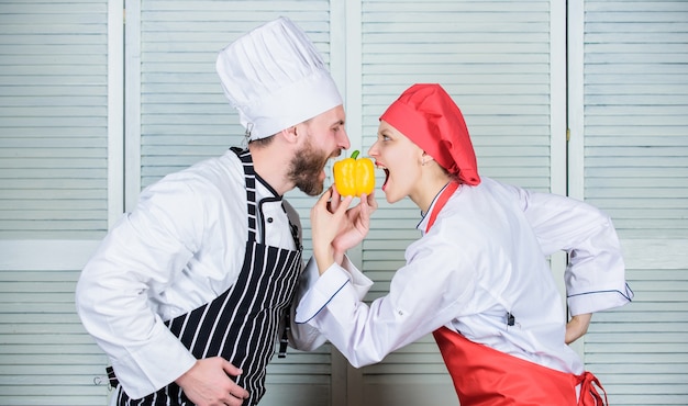 Mannkoch hält gelben Pfeffer. Probiere es einfach. Vegetarische Familie. Frau und bärtiger Mann kochen zusammen. Gesundes Essen kochen. Frisches vegetarisches gesundes Lebensmittelrezept. Frisches Gemüse. Schließen Sie sich einem gesunden Lebensstil an.