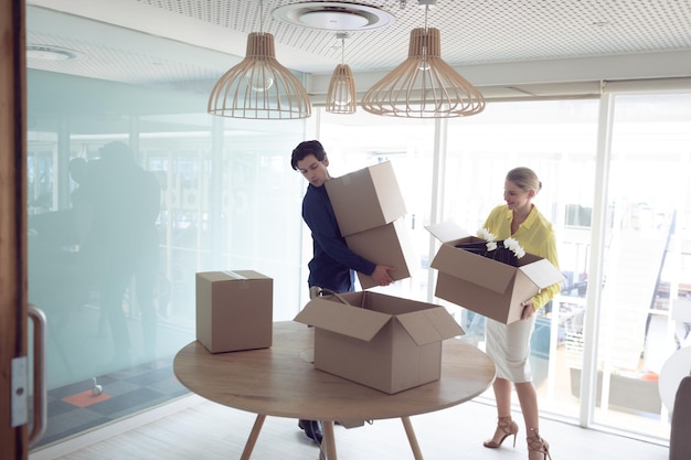 Mannliche und weibliche Führungskräfte mit Kartonkisten im Büro