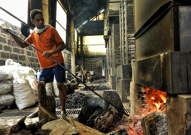 Foto mannlicher arbeiter, der in einer fabrik arbeitet