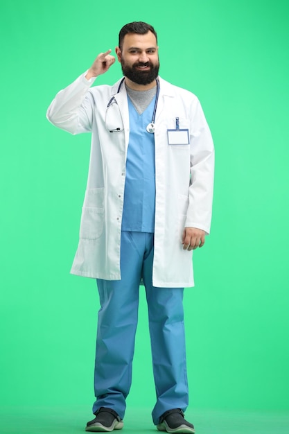 Mannlicher Arzt in voller Länge auf grünem Hintergrund