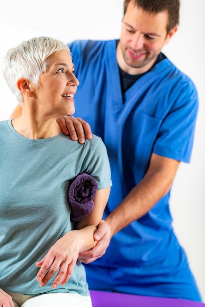 Foto mannlicher chiropraktiker, der eine weibliche patientin in einer klinik chiropraktically korrigiert