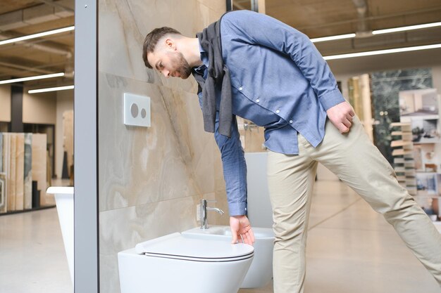 Mannlicher Kunde schaut sich Toiletten im Verkauf in einem modernen Geschäft oder Einkaufszentrum an