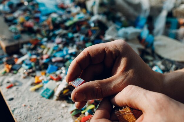 Mannmosaikmeister wählt ausgewählte Smalt-Glasstücke für Mosaikplatte aus Männlicher Mosaikmeister bei der Arbeit