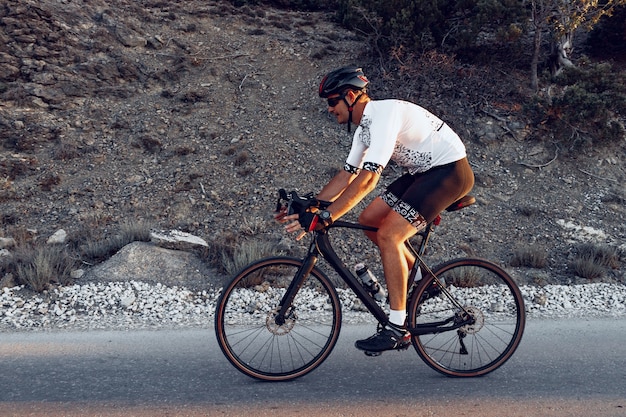 Mannradfahrer, der auf einem Rennrad im Freien tritt