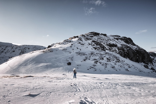 Mannreisender, der ein Foto auf schneebedecktem Berg im sonnigen macht