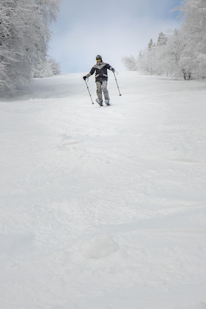 Mannskifahrer am Kopienraum der Skipiste