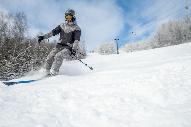 Mannskifahrer am Kopienraum der Skipiste