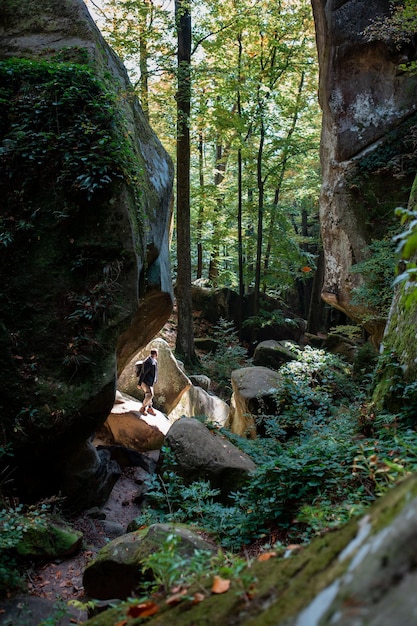 Mannwanderer mit Rucksack in der Schlucht mit Wald