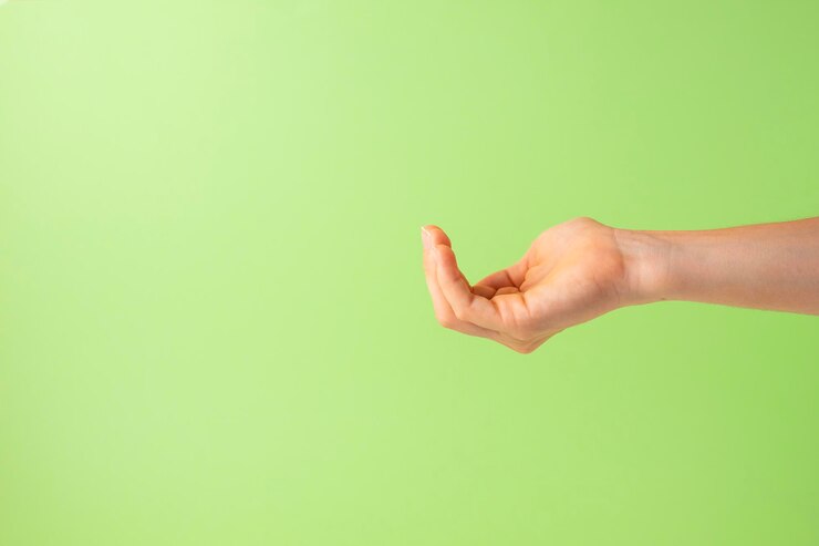 Foto mano abierta como si estuviera tomando algún objeto en fondo verde copiar espacio