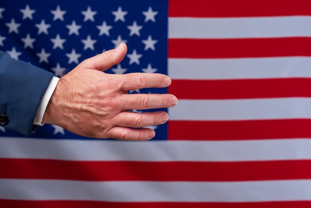 Mano abierta esperando ser sacudida con la bandera de los Estados Unidos en el negocio de fondo con los estadounidenses