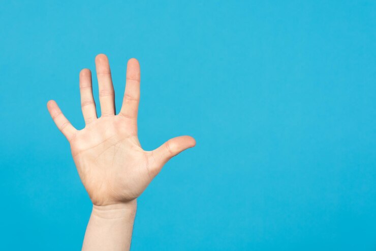 Foto mano abierta sobre fondo azul con espacio de copia